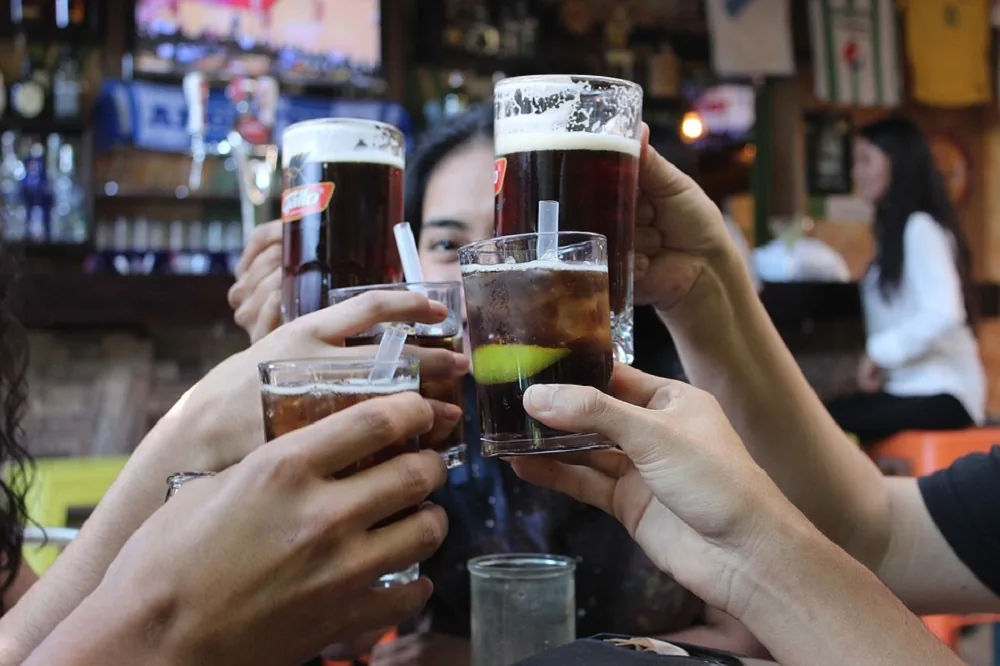Friends raising glasses in a pub with the atmosphere building